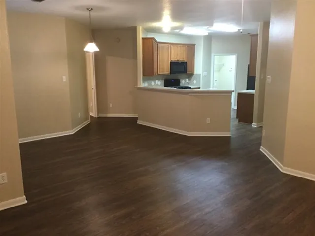 an empty room with wooden floor and mirror