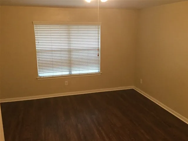 an empty room with wooden floor and a window