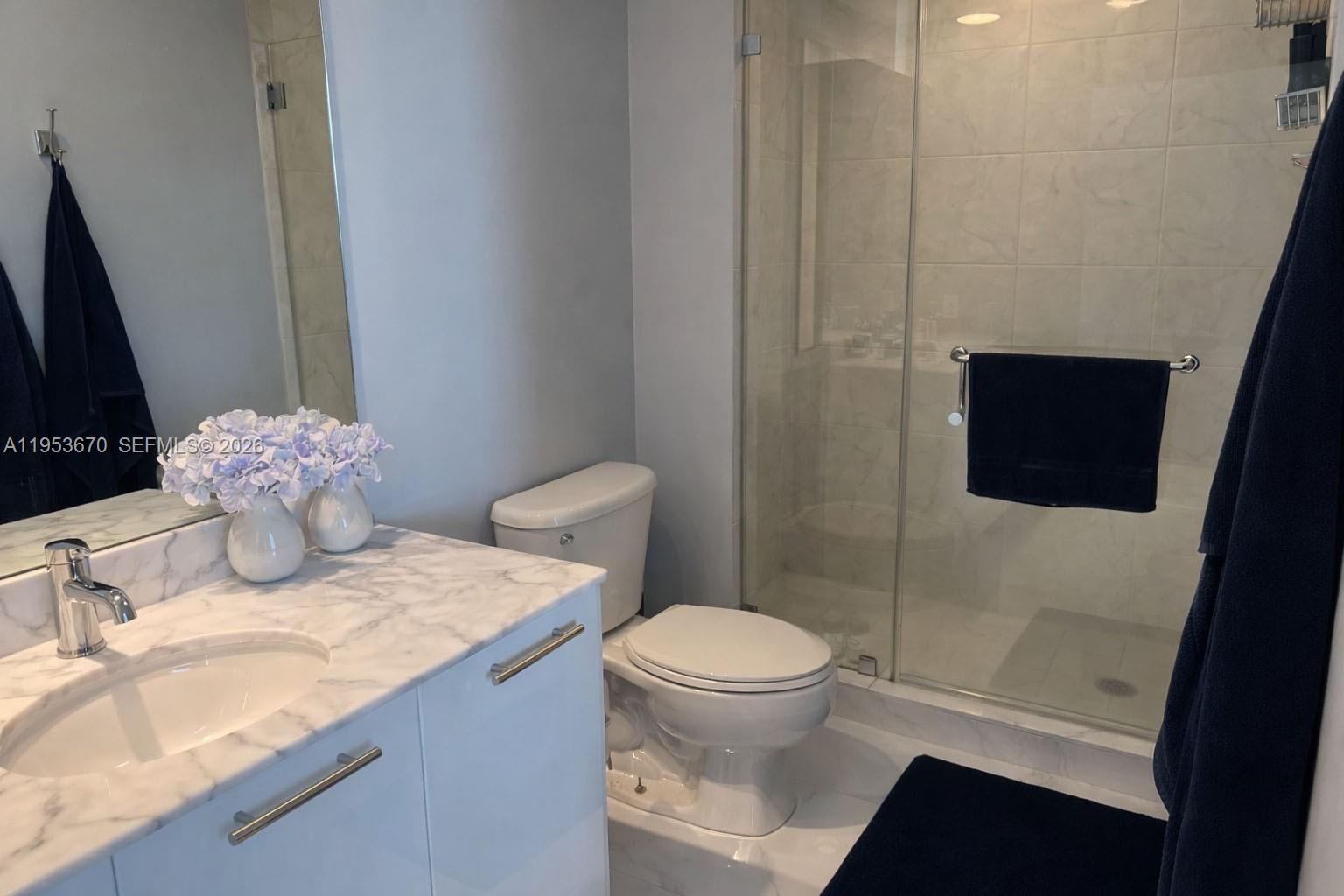 951 Brickell Avenue, Unit 3304 Miami, FL 33131 - Photo 13 of 28 a bathroom with a granite countertop sink toilet and shower