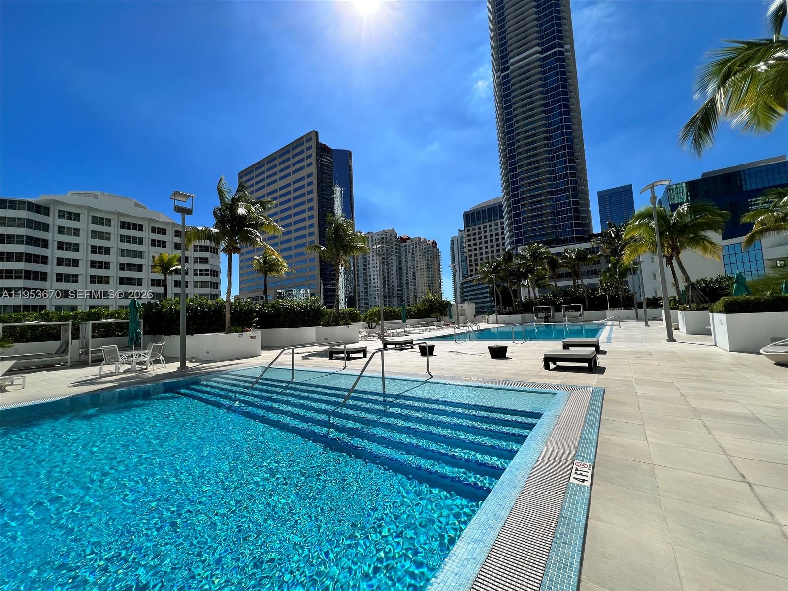951 Brickell Avenue, Unit 3304 Miami, FL 33131 - Photo 19 of 28 a view of a swimming pool with a lounge chairs
