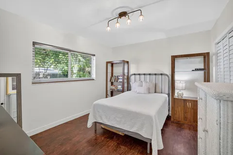 a spacious bedroom with a bed a couch and potted plant on the table