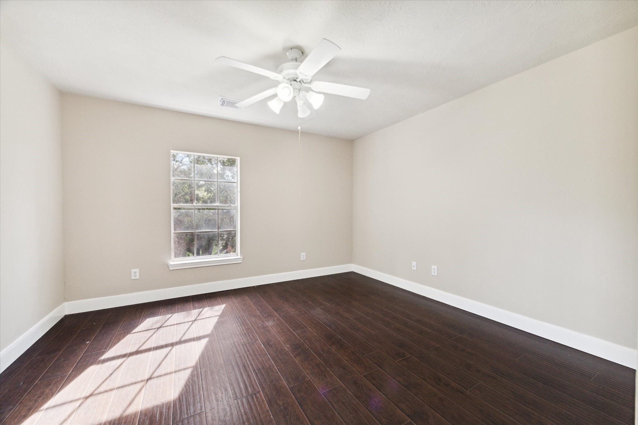 1818 Cross Spring Drive Sugar Land, TX 77479 - Photo 29 of 32 an empty room with wooden floor chandelier fan and windows