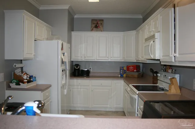 a kitchen with white cabinets and white appliances