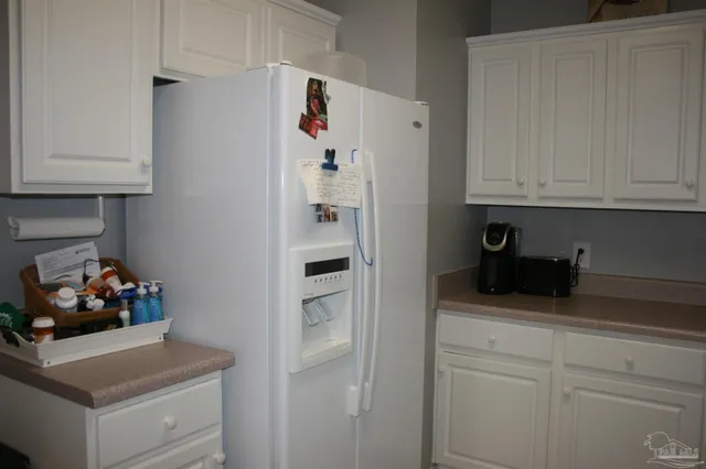 a kitchen with white cabinets and sink