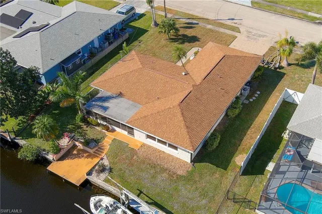 an aerial view of lake and residential houses with outdoor space and swimming pool