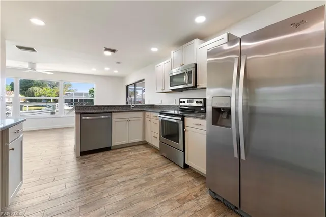 a kitchen with stainless steel appliances granite countertop a sink stove and refrigerator