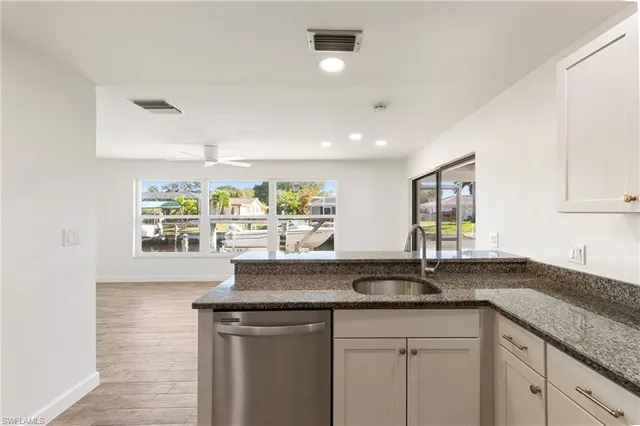 a view of kitchen with kitchen island microwave and cabinets