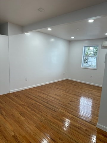 37 Cedar Street, Unit 1 Lawrence, MA 01841 - Photo 5 of 6 an empty room with wooden floor and windows