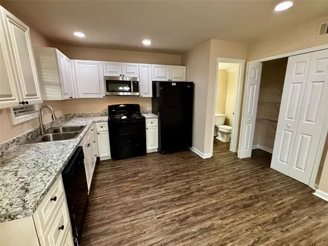 a kitchen with stainless steel appliances granite countertop a refrigerator stove microwave and sink