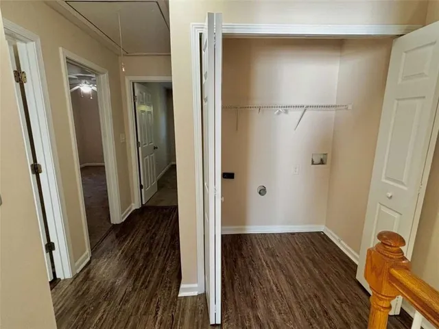 a view of a hallway with wooden floor and closet