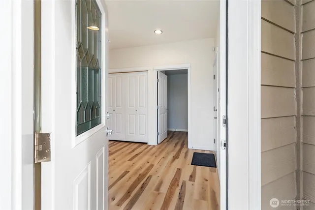 a view of a hallway with wooden floor and staircase