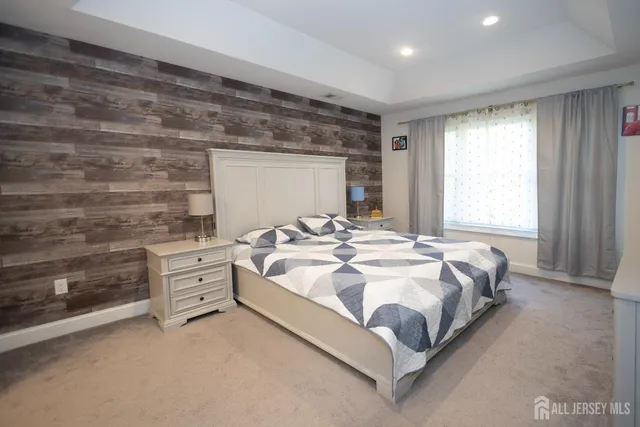 a bedroom with a bed and a flat tv screen on dresser