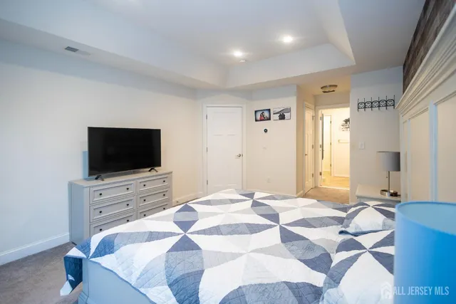 a spacious bedroom with a bed and a flat screen tv