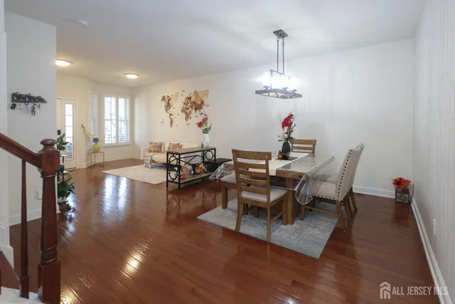 a view of a dining room and livingroom with furniture wooden floor a chandelier
