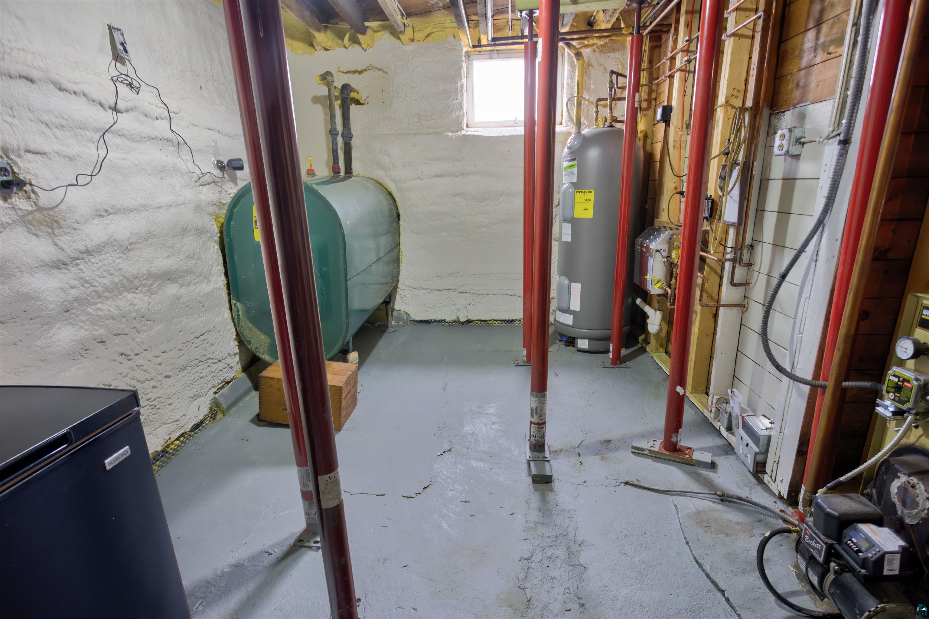 24 East Conan Street Ely, MN 55731 - Photo 27 of 27 Basement utility area featuring a hot water heater, fuel storage tank, and spray foam insulation