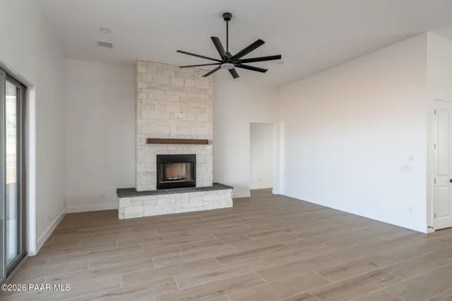 a view of an empty room with a fireplace and a window