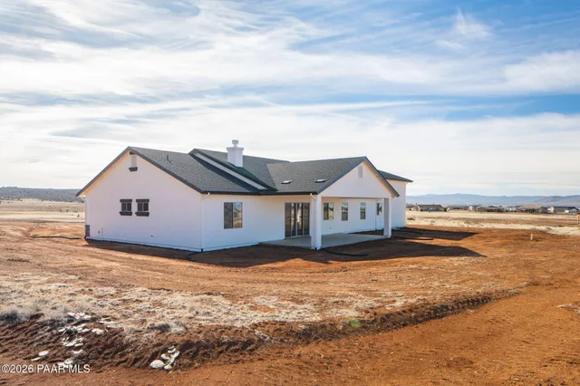 a view of a house with a yard next to a large building