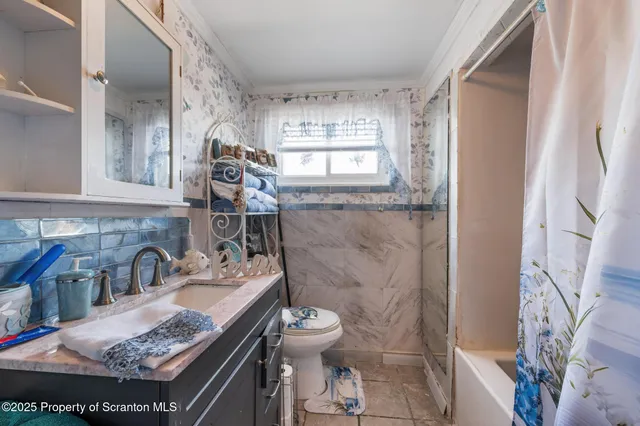 a bathroom with a granite countertop sink a toilet and a shower