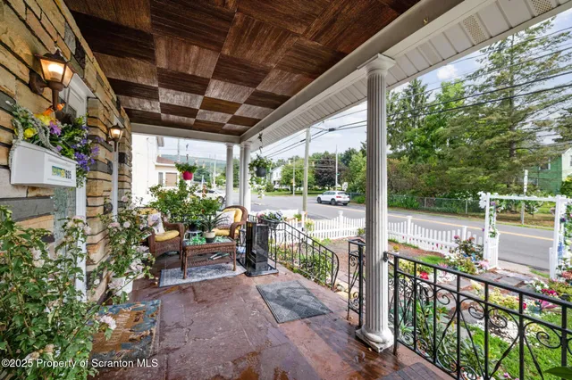 a view of a porch with chairs and potted plants