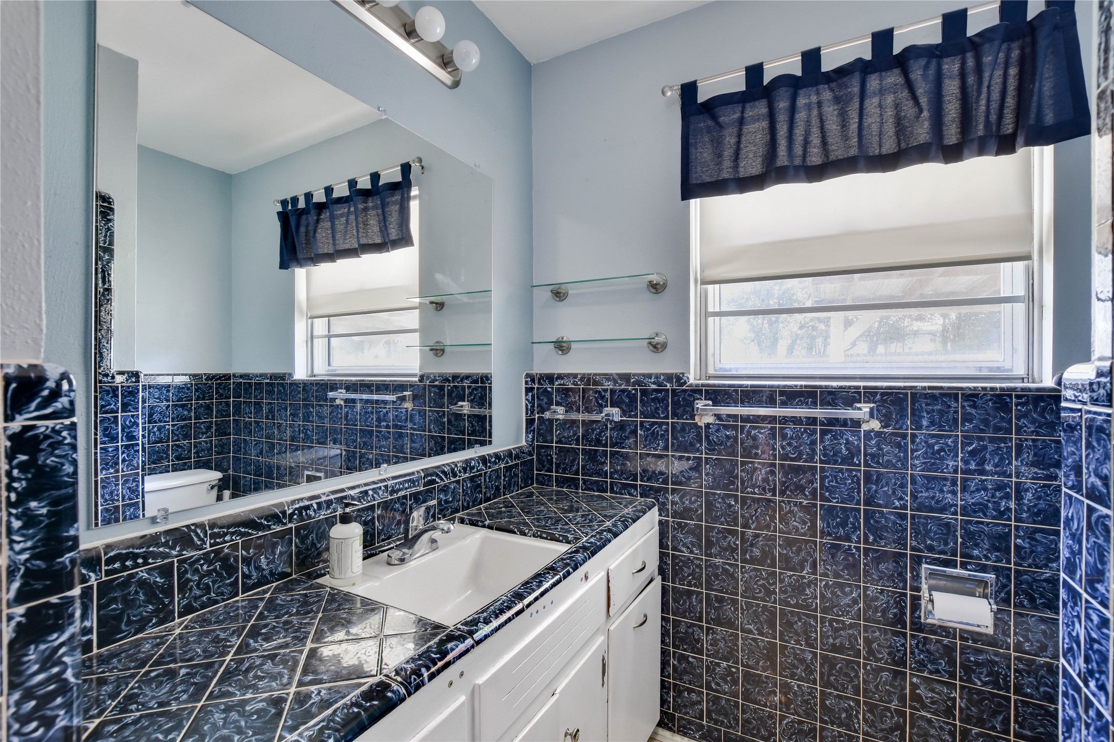 3317 Bosque Lane Austin, TX 78754 - Photo 14 of 18 a bathroom with a granite countertop sink a mirror and a shower