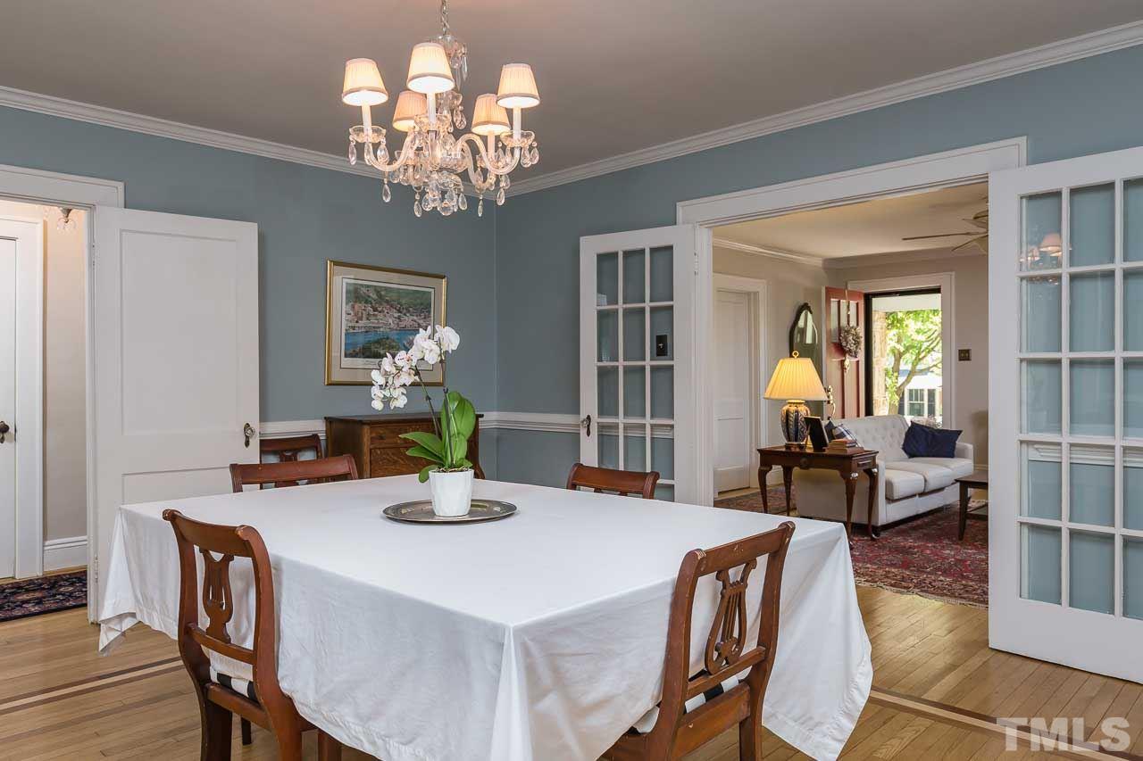 115 East Whitaker Mill Road Raleigh, NC 27608 - Photo 7 of 24 a dining room with wooden floor a chandelier a wooden table and chairs