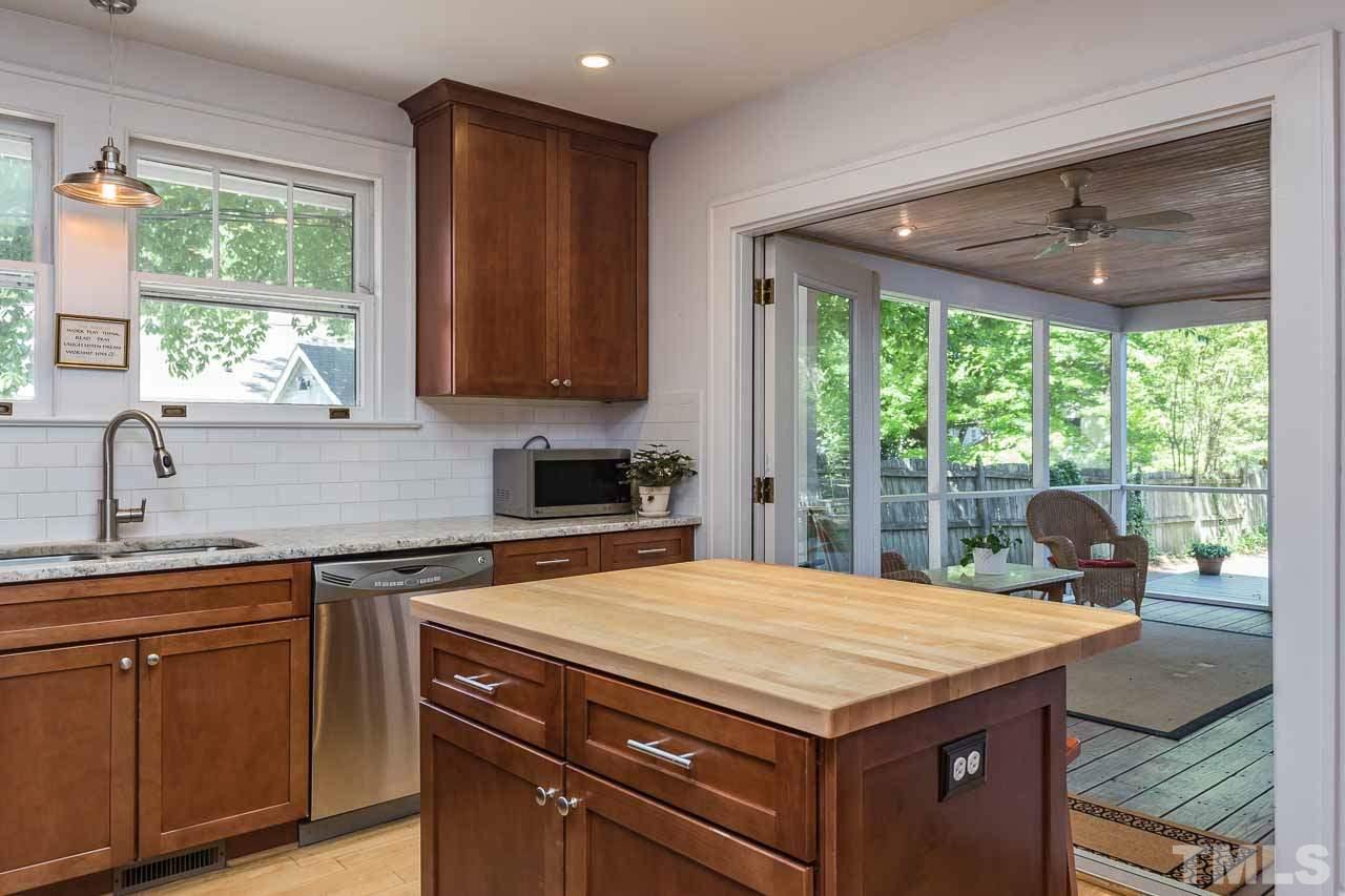 115 East Whitaker Mill Road Raleigh, NC 27608 - Photo 9 of 24 a kitchen with a stove a sink a refrigerator and window