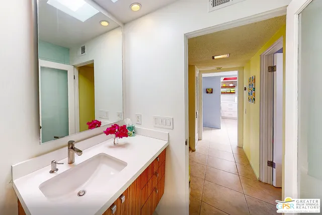 a en suite bathroom with a sink vanity and a mirror