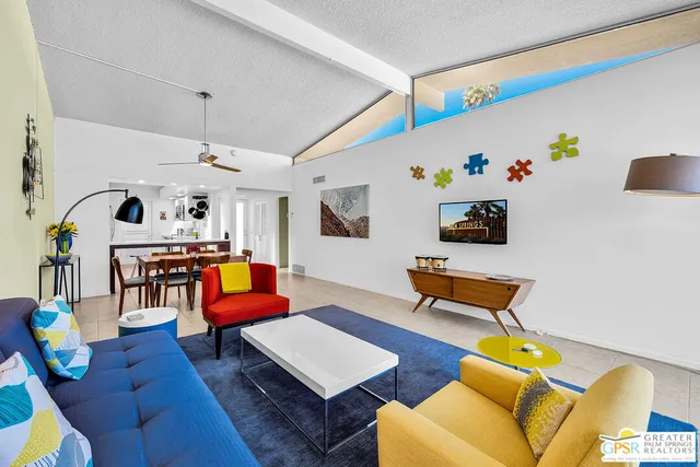 a living room with furniture kitchen view and a table