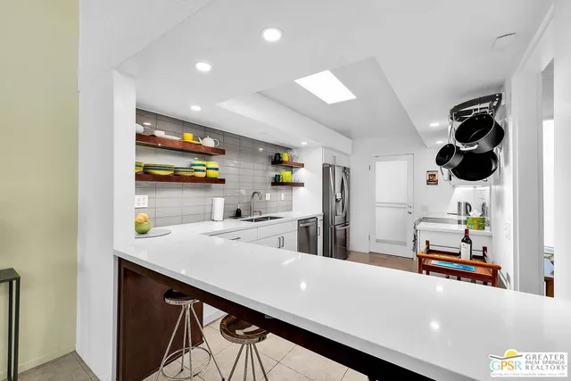 a kitchen with stainless steel appliances cabinets and wooden floor