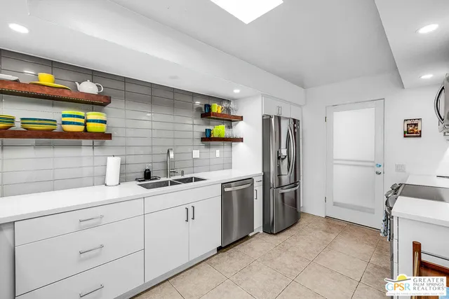 a kitchen with stainless steel appliances a refrigerator sink and stove
