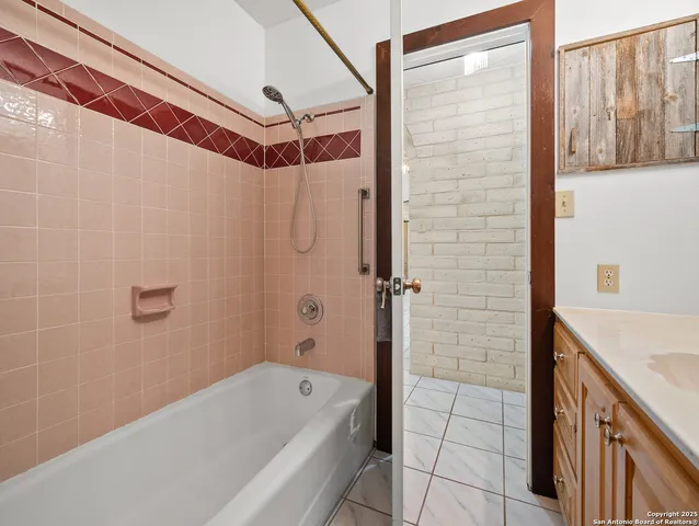 a bathroom with a tub a sink and a shower