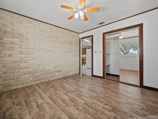 a view of an empty room with window and wooden floor