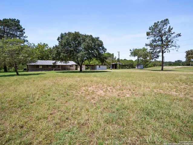 a view of a green field with trees in the background
