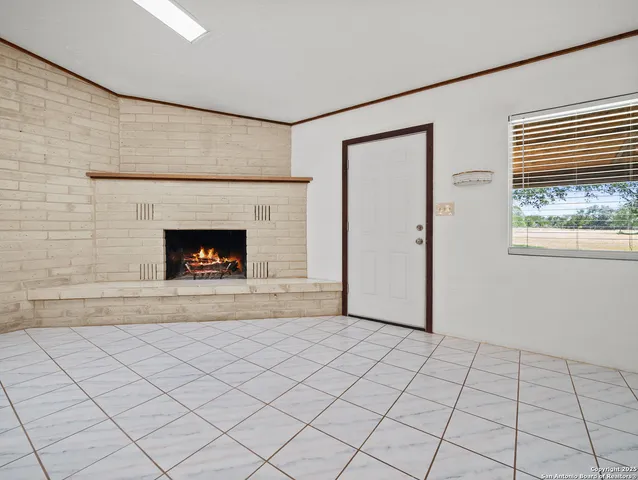 a view of an empty room with window and fire place