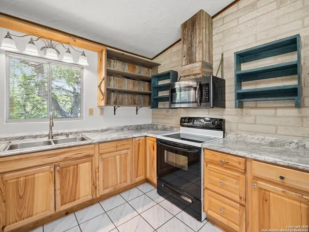 a kitchen with stainless steel appliances granite countertop a sink and a stove