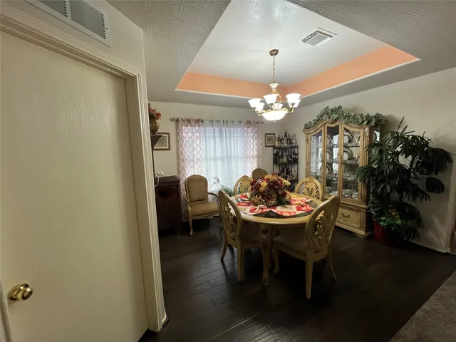 a view of a dining room with furniture and chandelier