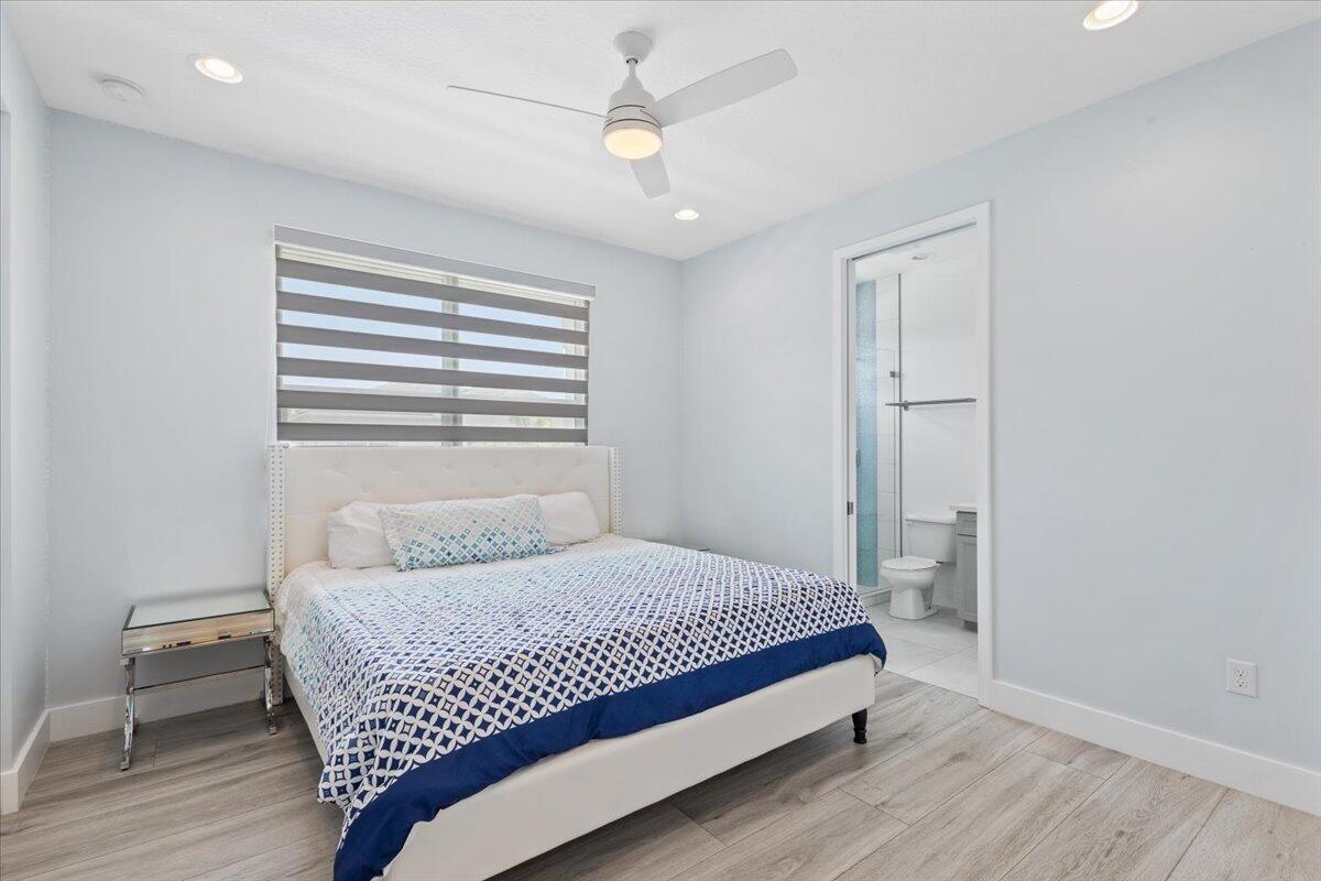 15377 Green River Court Delray Beach, FL 33446 - Photo 33 of 49 a bedroom with a bed and a chandelier