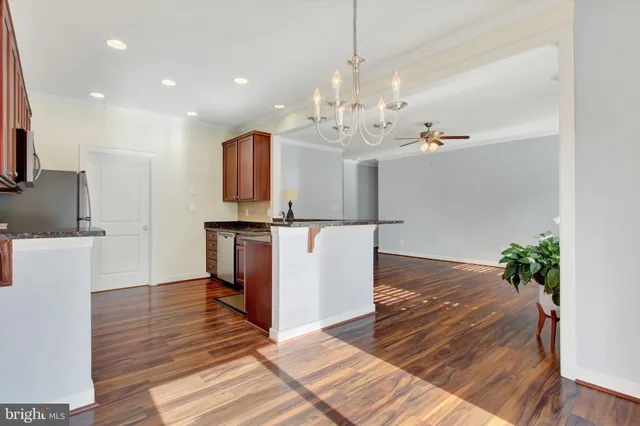 a kitchen with kitchen island granite countertop a refrigerator and a stove top oven