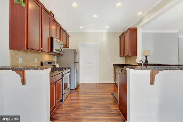 a kitchen with granite countertop a sink stove and cabinets