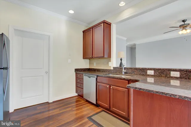 a kitchen with stainless steel appliances granite countertop sink stove and wooden cabinets