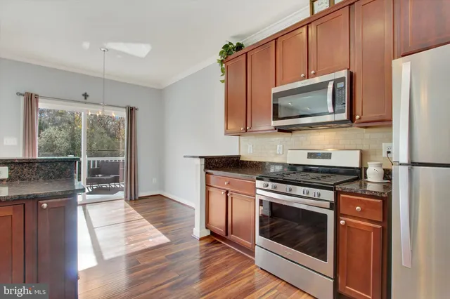 a kitchen with stainless steel appliances granite countertop a stove microwave and refrigerator