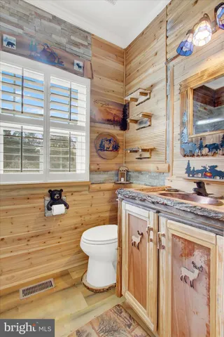 a bathroom with a granite countertop sink mirror vanity and toilet