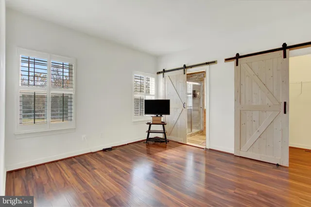 a view of an empty room with wooden floor
