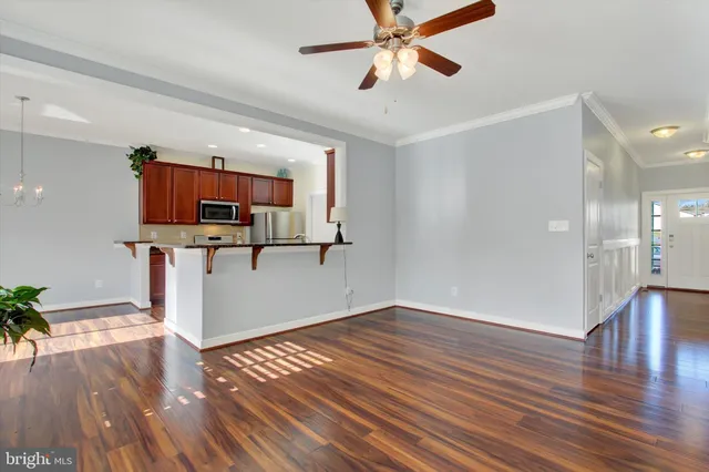 a view of a kitchen with wooden floor and electronic appliances