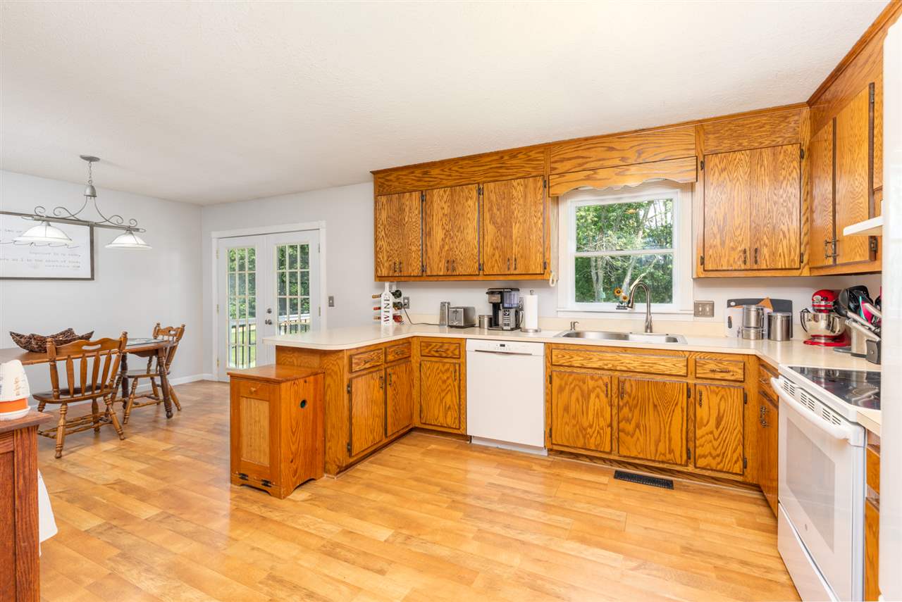 104 Buckboard Road Waynesboro, VA 22980 - Photo 12 of 43 a large kitchen with stainless steel appliances granite countertop a sink a stove a dining table and chairs with wooden floor