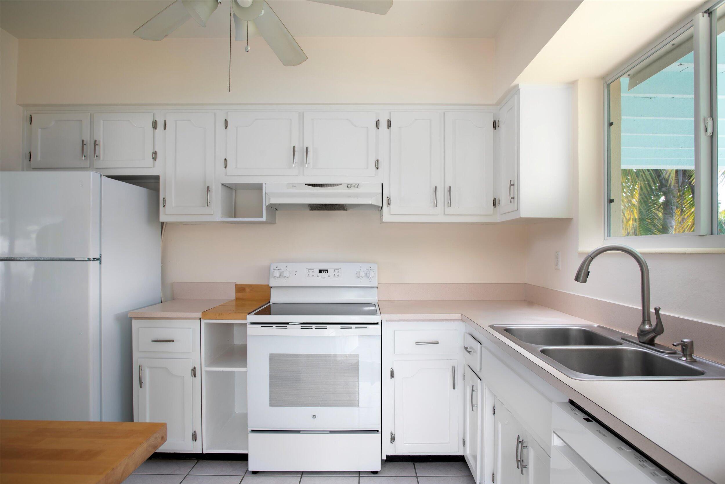 1228 11th Street Key West, FL 33040 - Photo 8 of 17 a kitchen with cabinets appliances a sink and a counter space