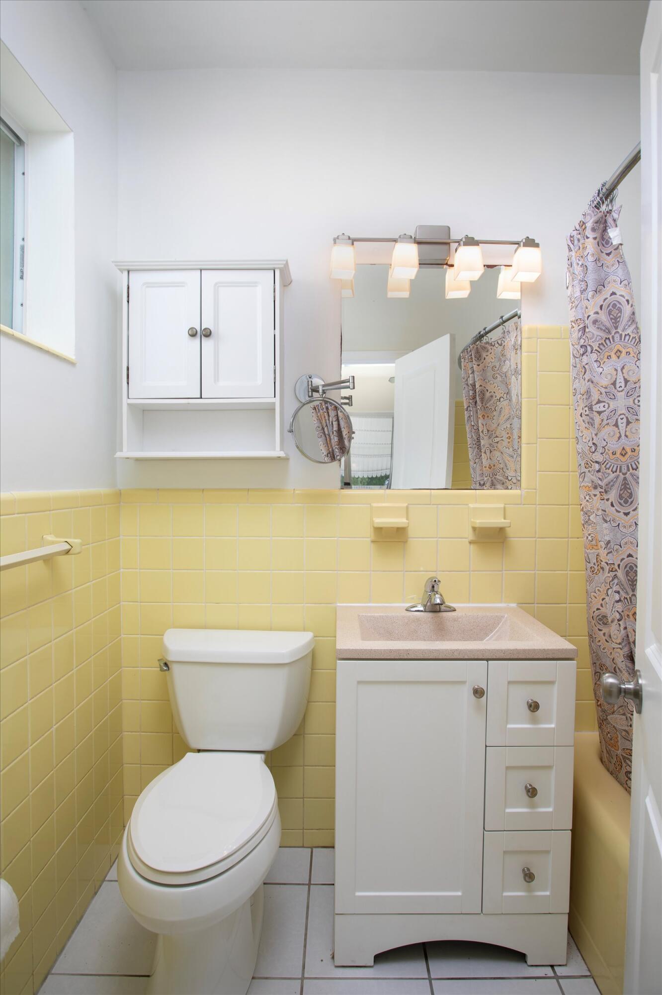 1228 11th Street Key West, FL 33040 - Photo 10 of 17 a bathroom with a toilet sink vanity and mirror