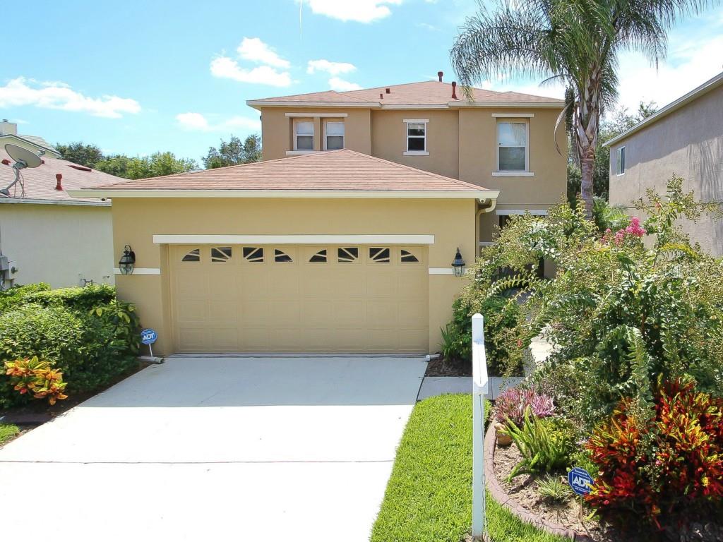 2316 Spring Hollow Loop Wesley Chapel, FL 33544 - Photo 1 of 1 a view of a white house with a small yard plants and a large tree