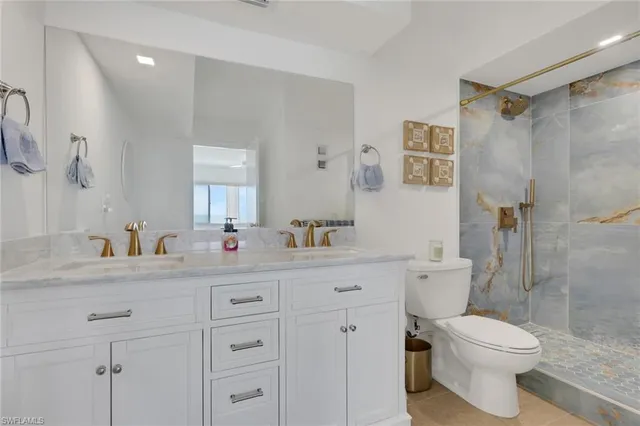 a bathroom with a granite countertop toilet sink and a mirror