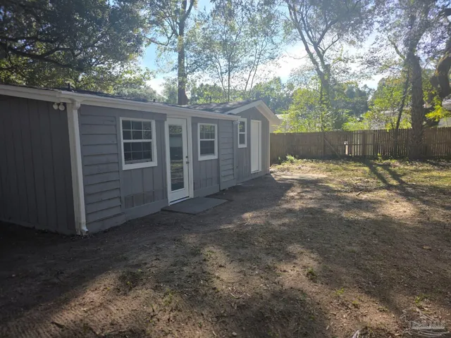 a view of a yard with large tree and wooden fence